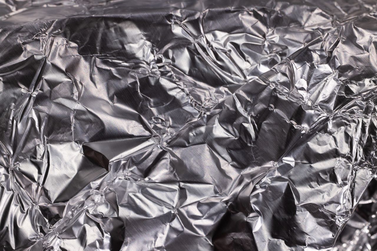 Strona główna Close-up of shiny crumpled aluminum foil showcasing metallic wrinkled texture.
