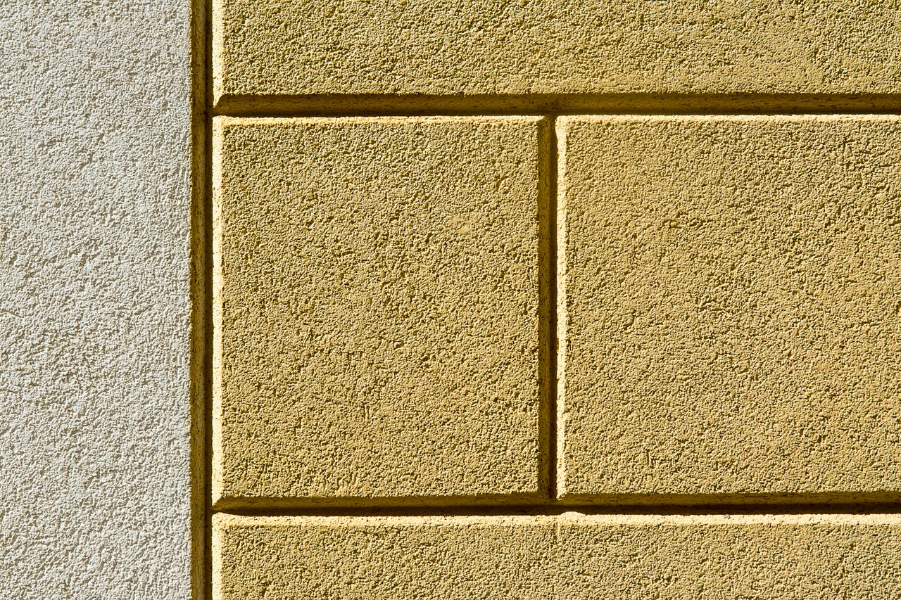 Crafting Captivating Headlines: Your awesome post title goes here Detailed textured surface of a yellow painted cement wall with shadow effects.