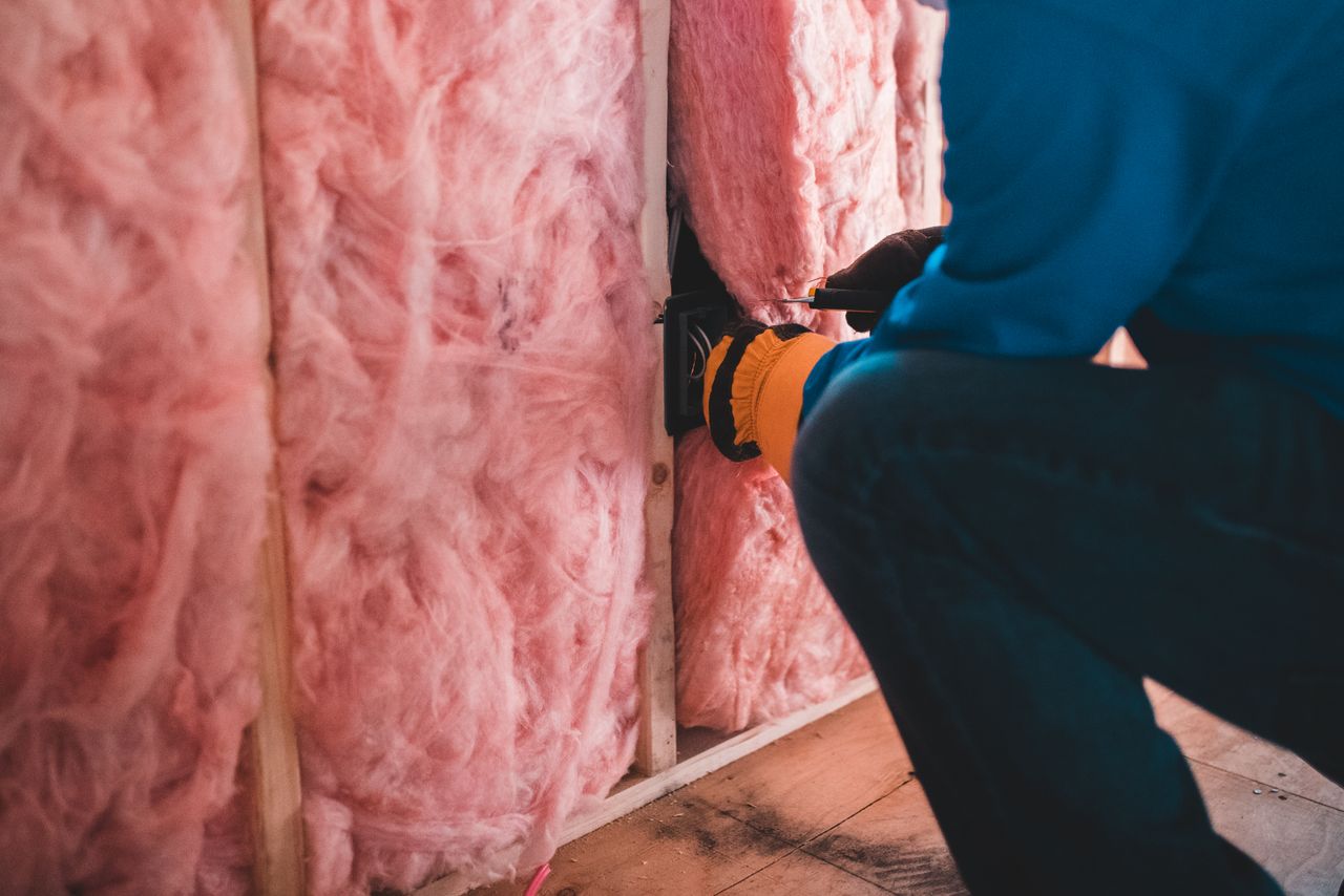 The Art of Drawing Readers In: Your attractive post title goes here Crop unrecognizable worker in gloves sitting on haunches and insulating with pink stone wool